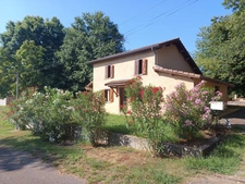 Maison à trois chambres avec un double garage située dans un environnement boisé sans voisins.