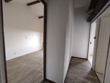 Maison à trois chambres avec un double garage située dans un environnement boisé sans voisins.