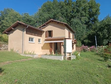Maison à trois chambres avec un double garage située dans un environnement boisé sans voisins.