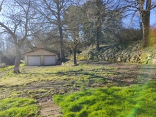 Maison à trois chambres avec un double garage située dans un environnement boisé sans voisins.