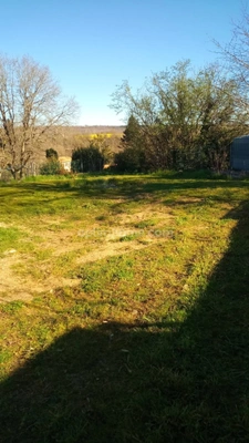 MARTHON Terrain CU de 911 m² clos, avec deux garages fermés.